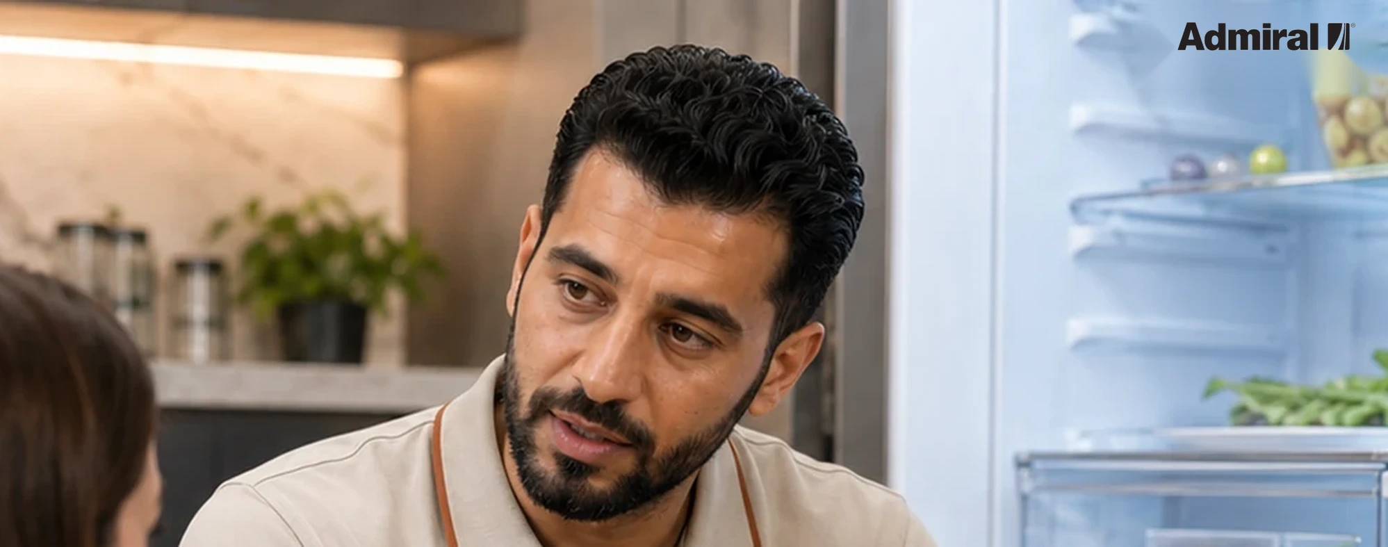 فني صيانة أدميرال مع عميل أثناء فحص جهاز منزلي